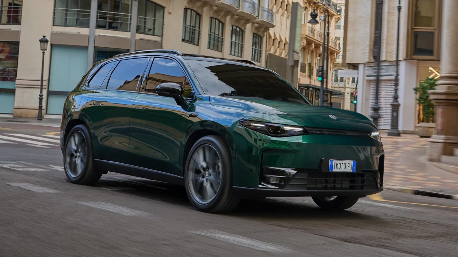 une voiture verte descendant une rue