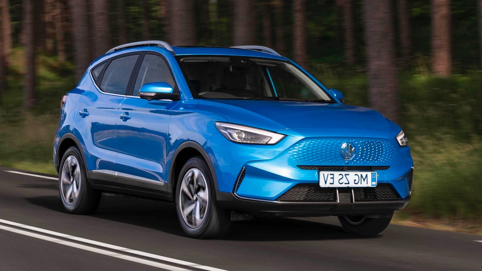 a blue car driving on a road