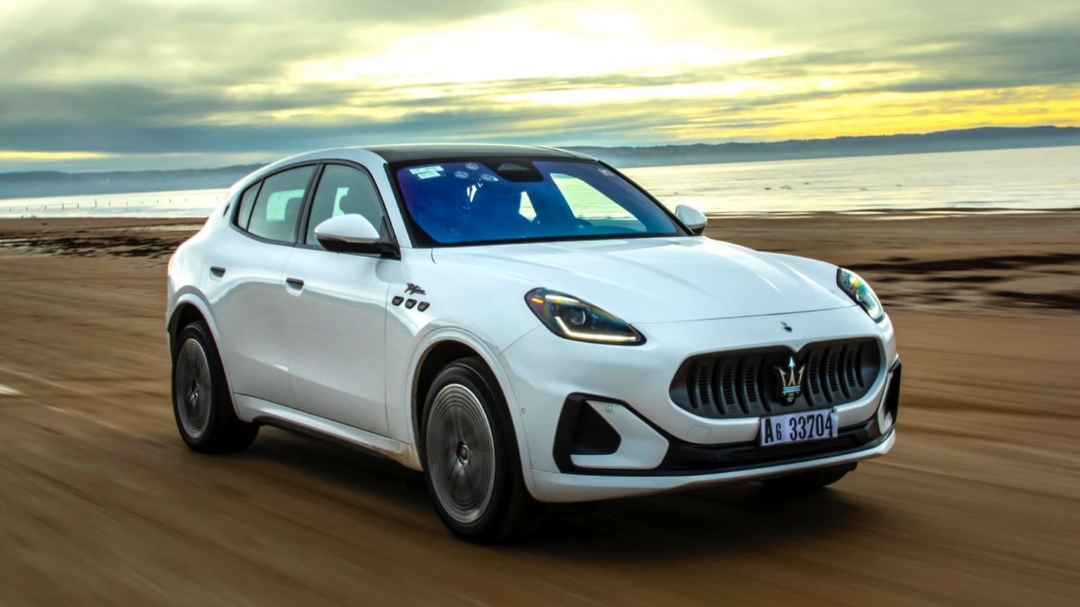 a white car driving on a dirt road