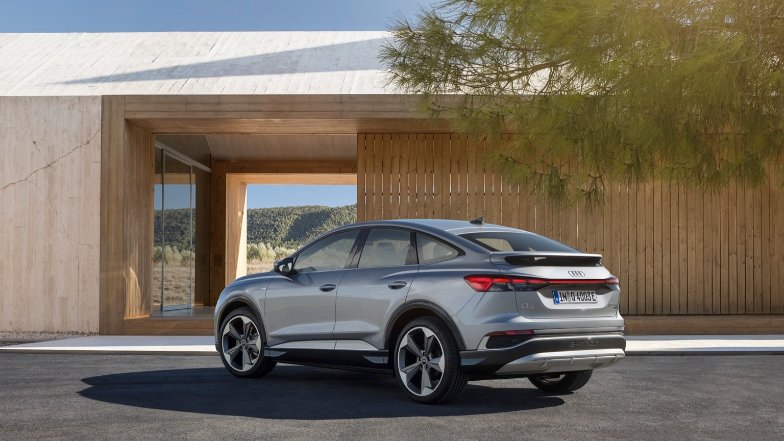 a silver car parked in front of a wood building