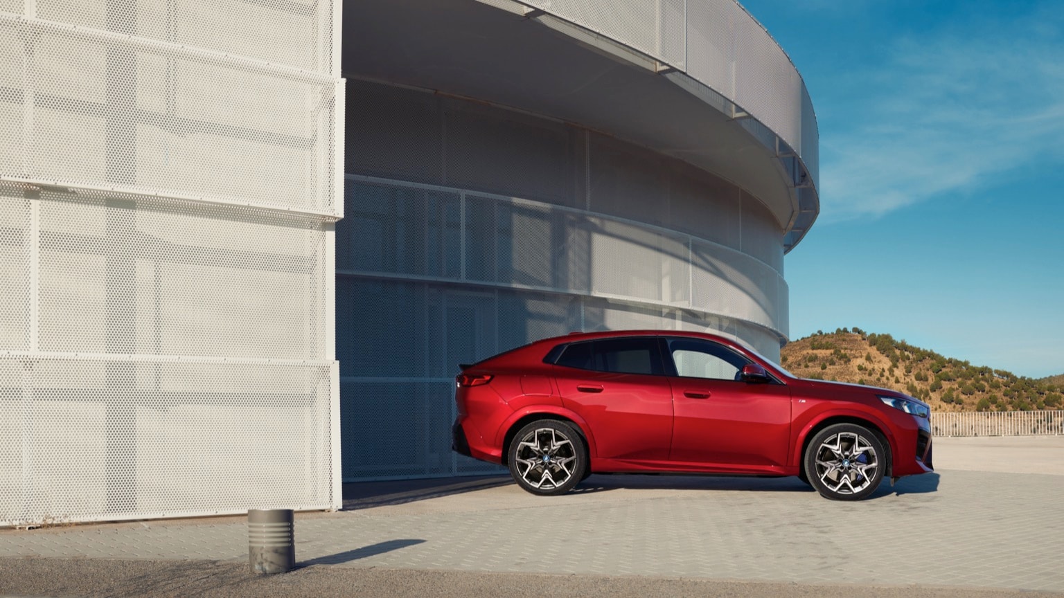 une voiture rouge garée devant un bâtiment