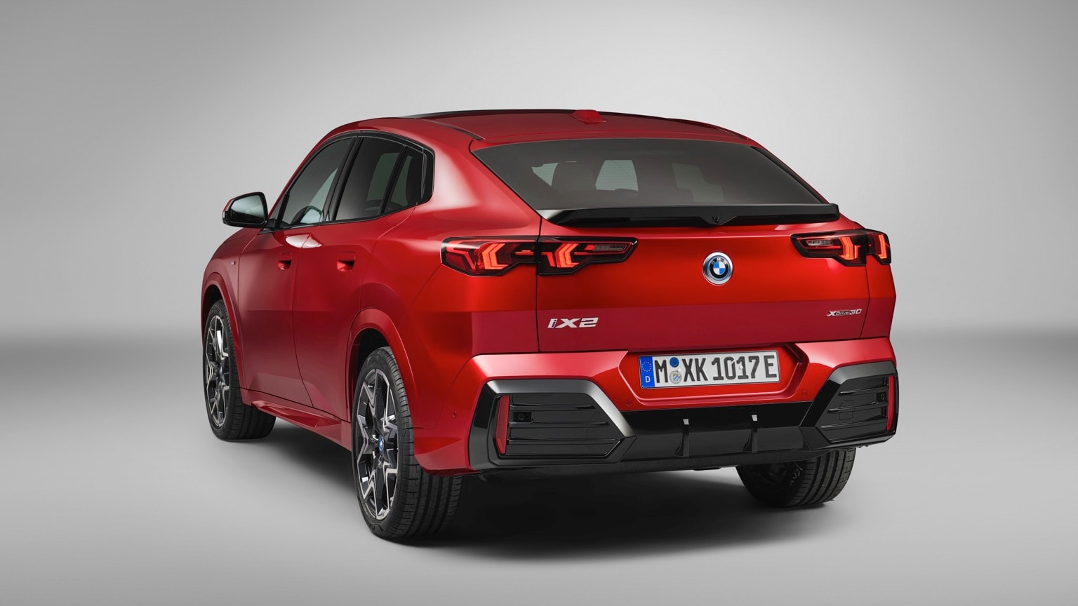 une voiture rouge avec des garnitures noires avec l'Arboretum de Holden en arrière-plan