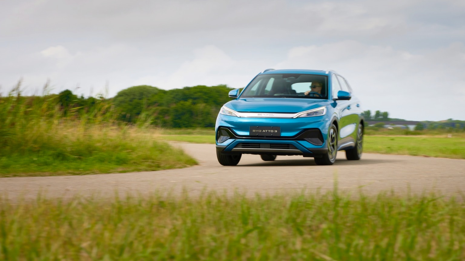 une voiture bleue roulant sur une route