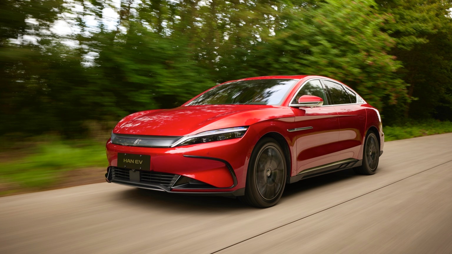 une voiture rouge roulant sur une route