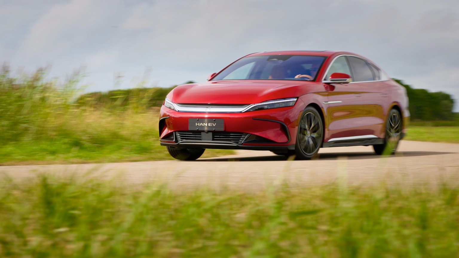 une voiture rouge roulant sur une route