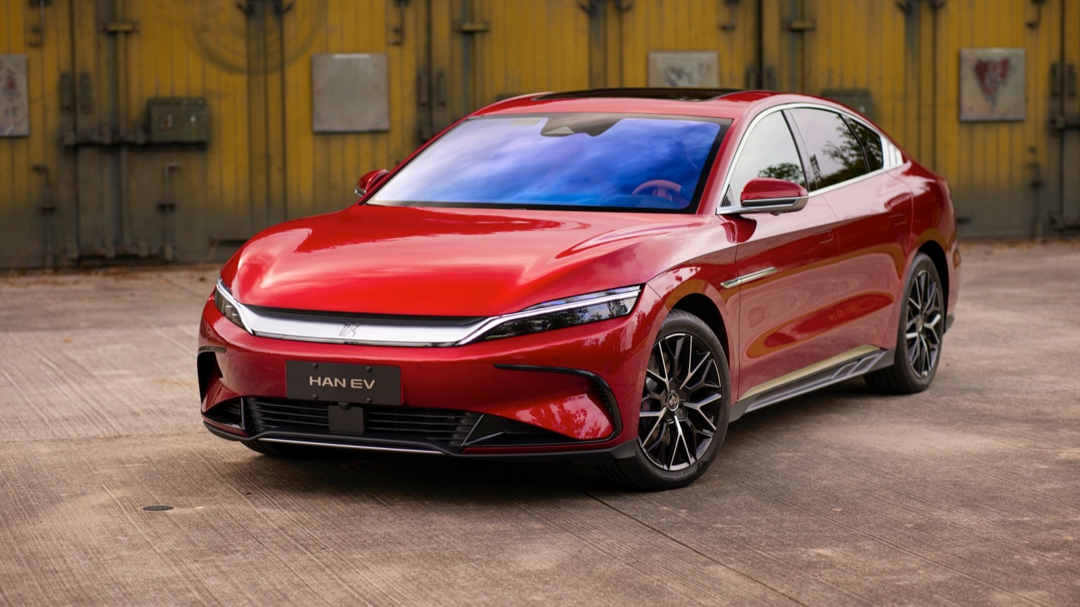 une voiture rouge garée sur du béton