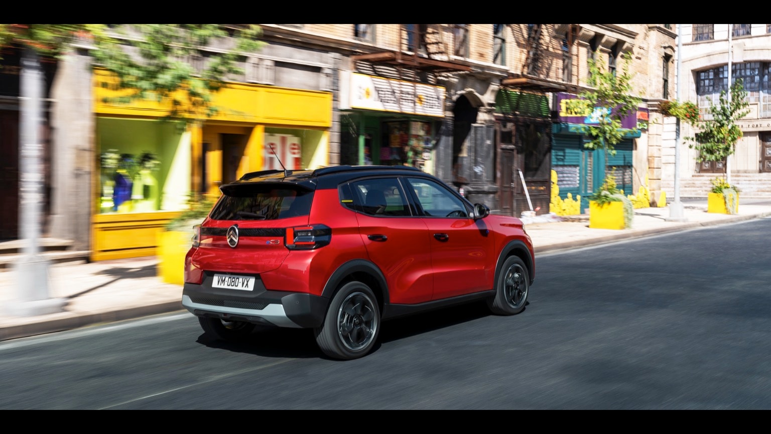 une voiture rouge descendant la rue
