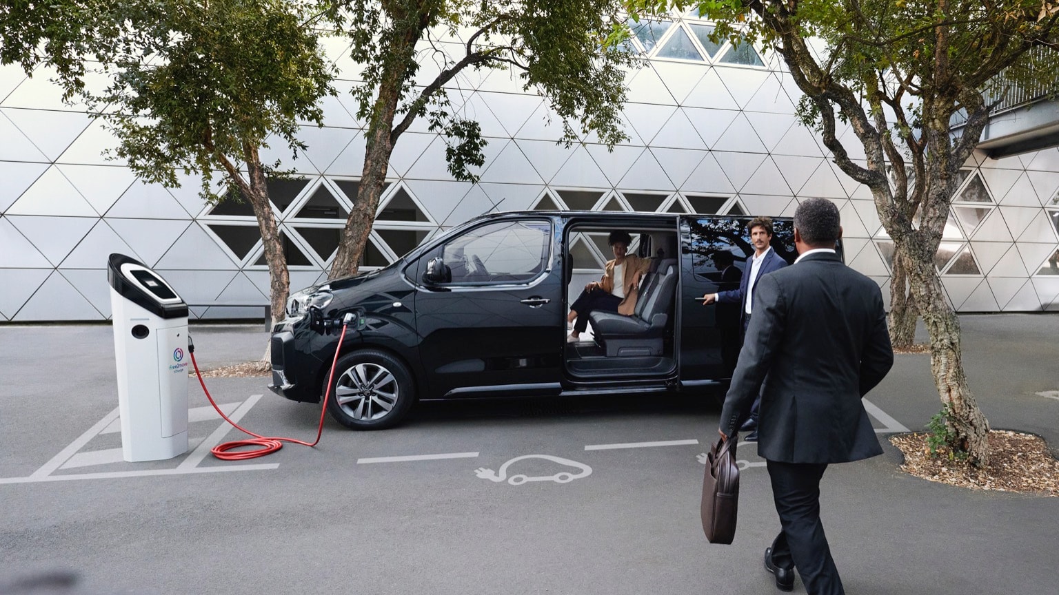 un homme en costume qui monte dans une voiture