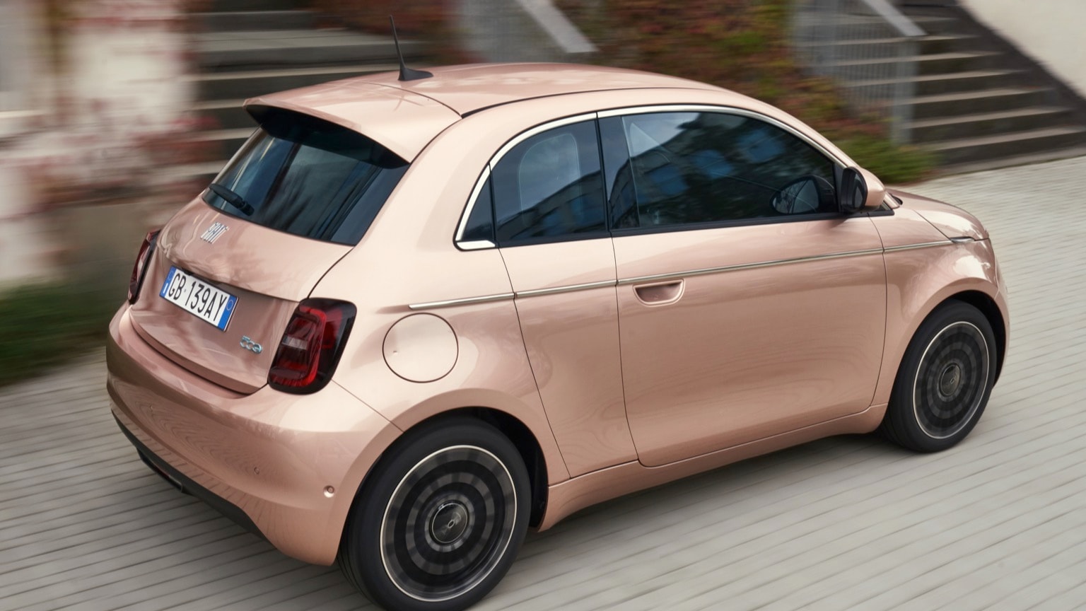 a small pink car on a road