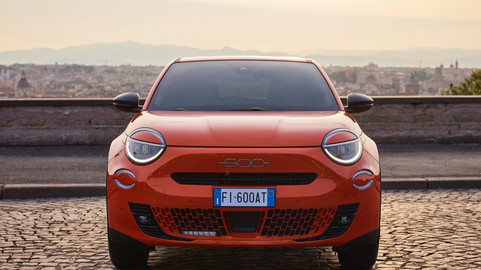 une voiture rouge garée sur une surface en briques