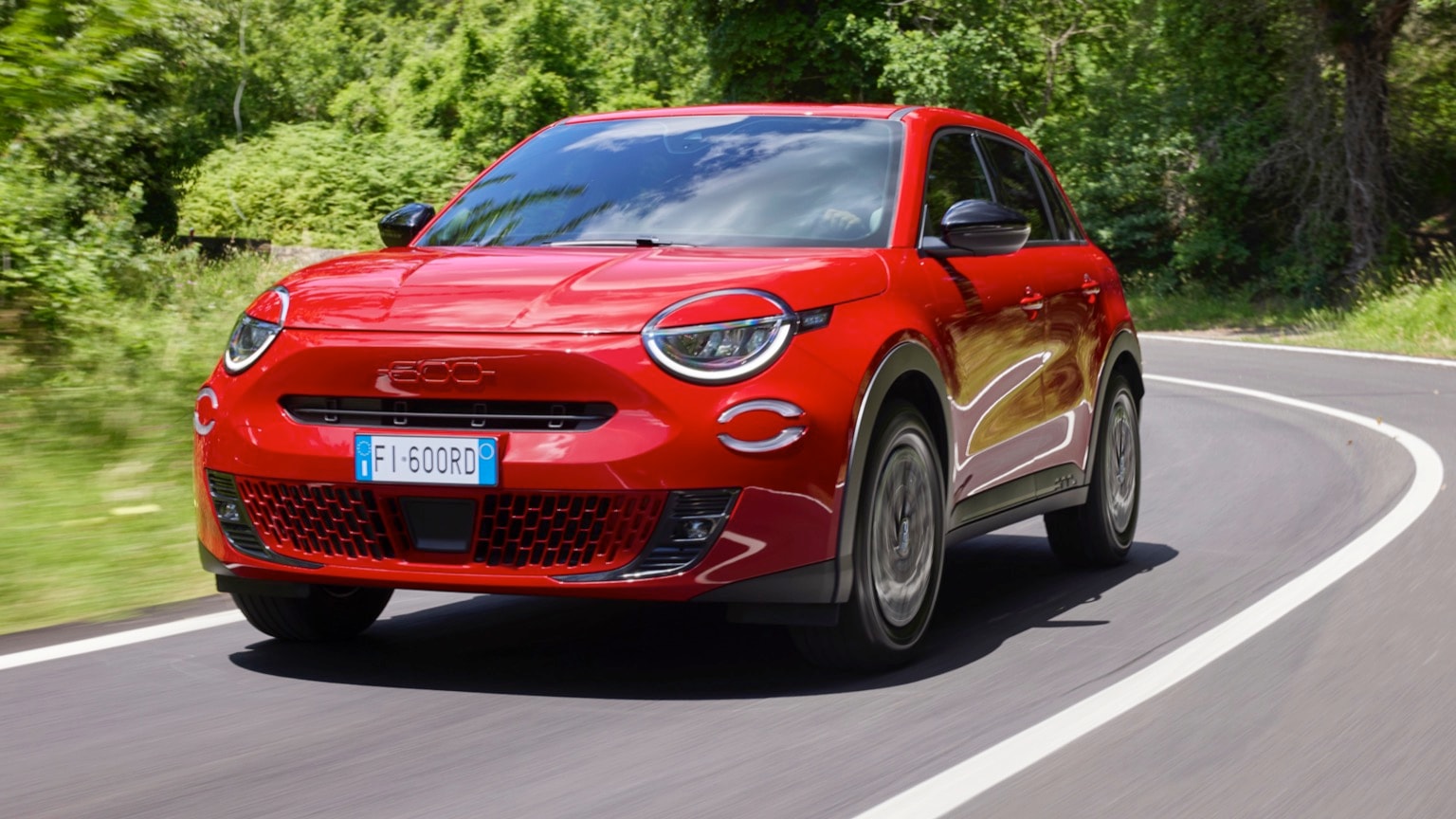 une voiture rouge roulant sur une route