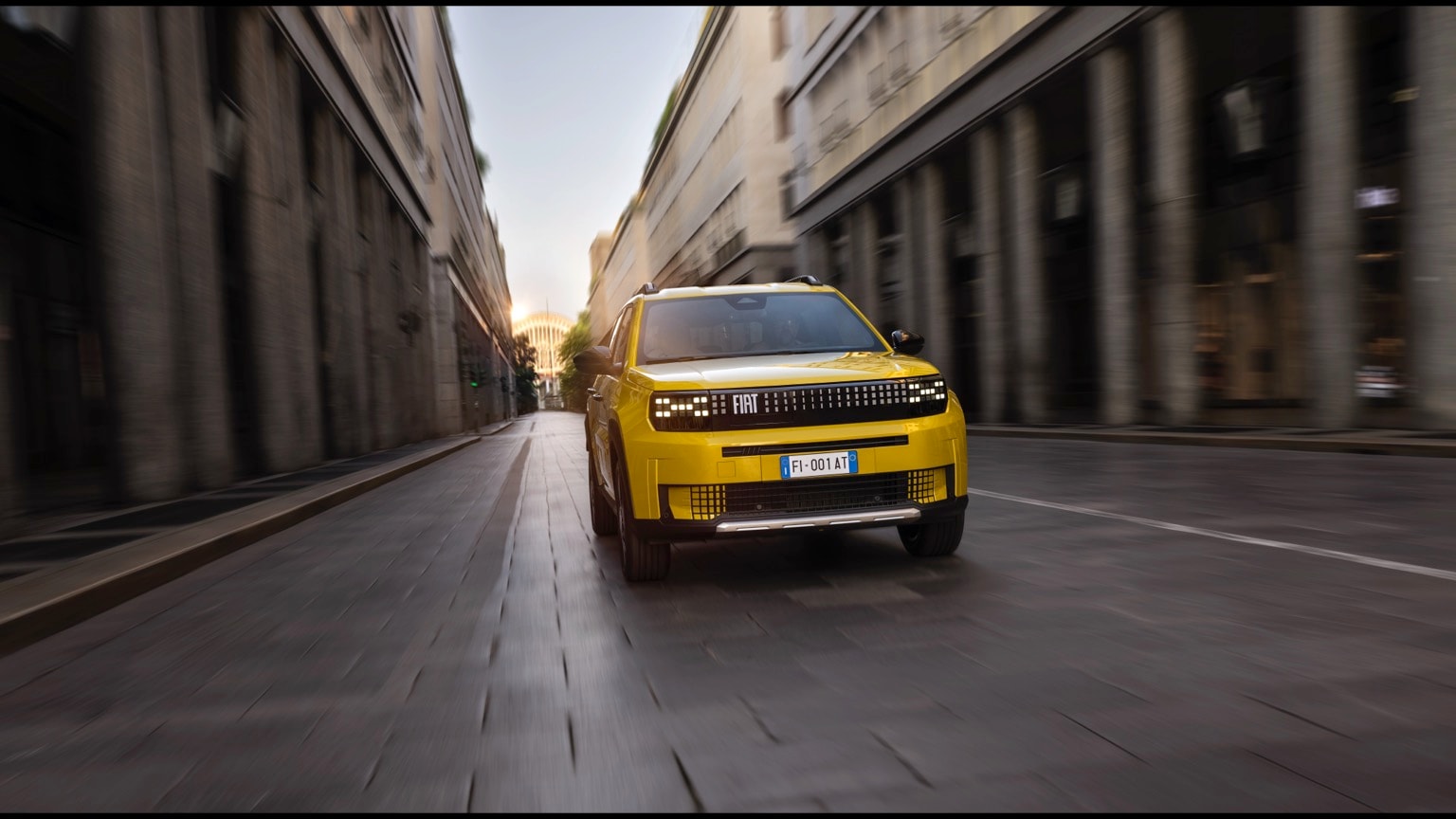 une voiture jaune descendant une rue