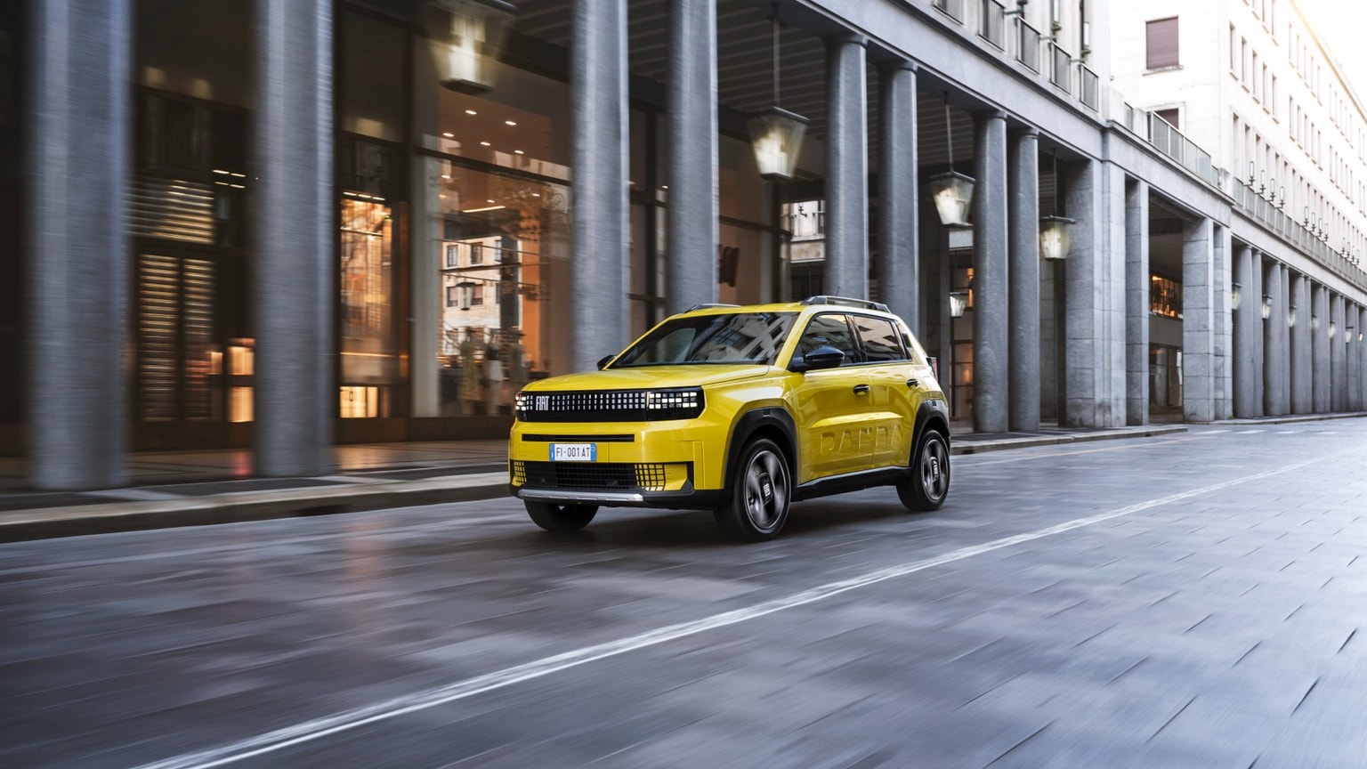 une voiture jaune descendant une rue