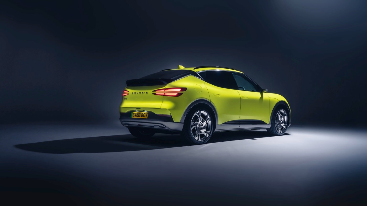 a green car parked in a dark room