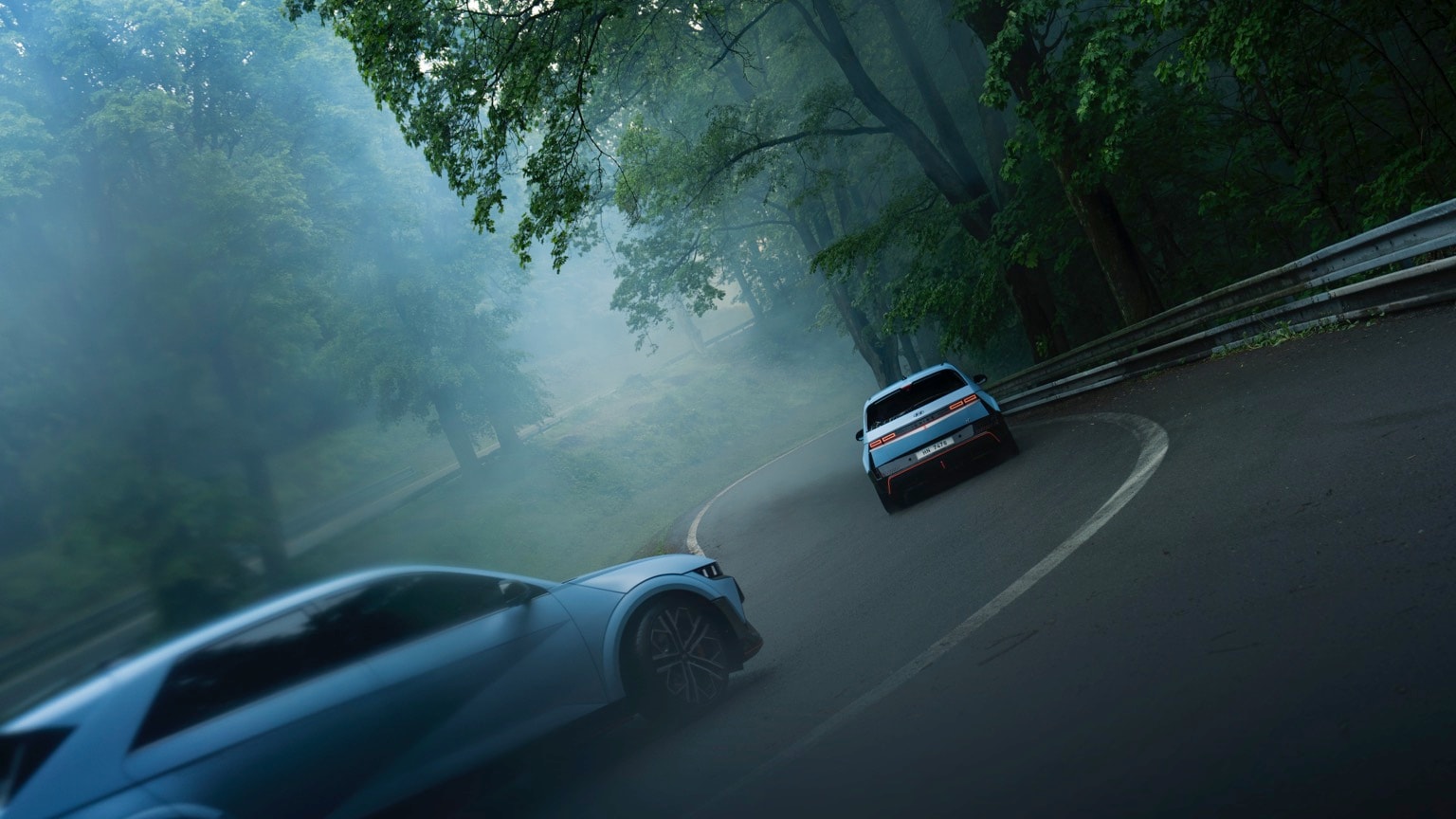 two cars driving on a road