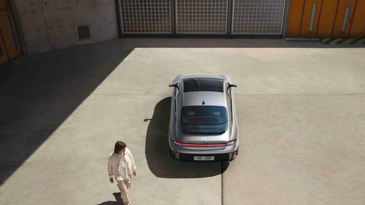 a man walking next to a silver car