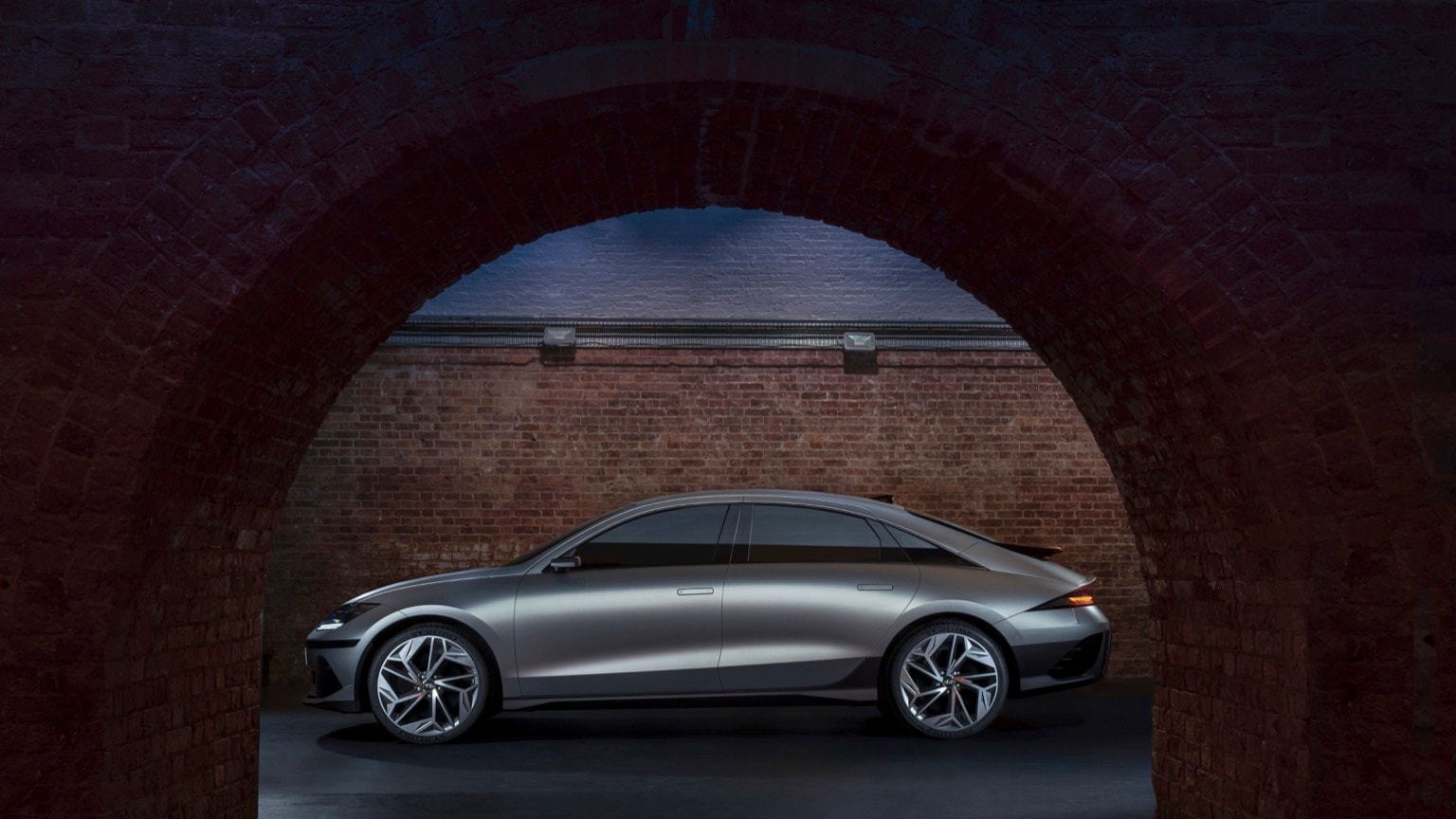 a silver car in a brick tunnel