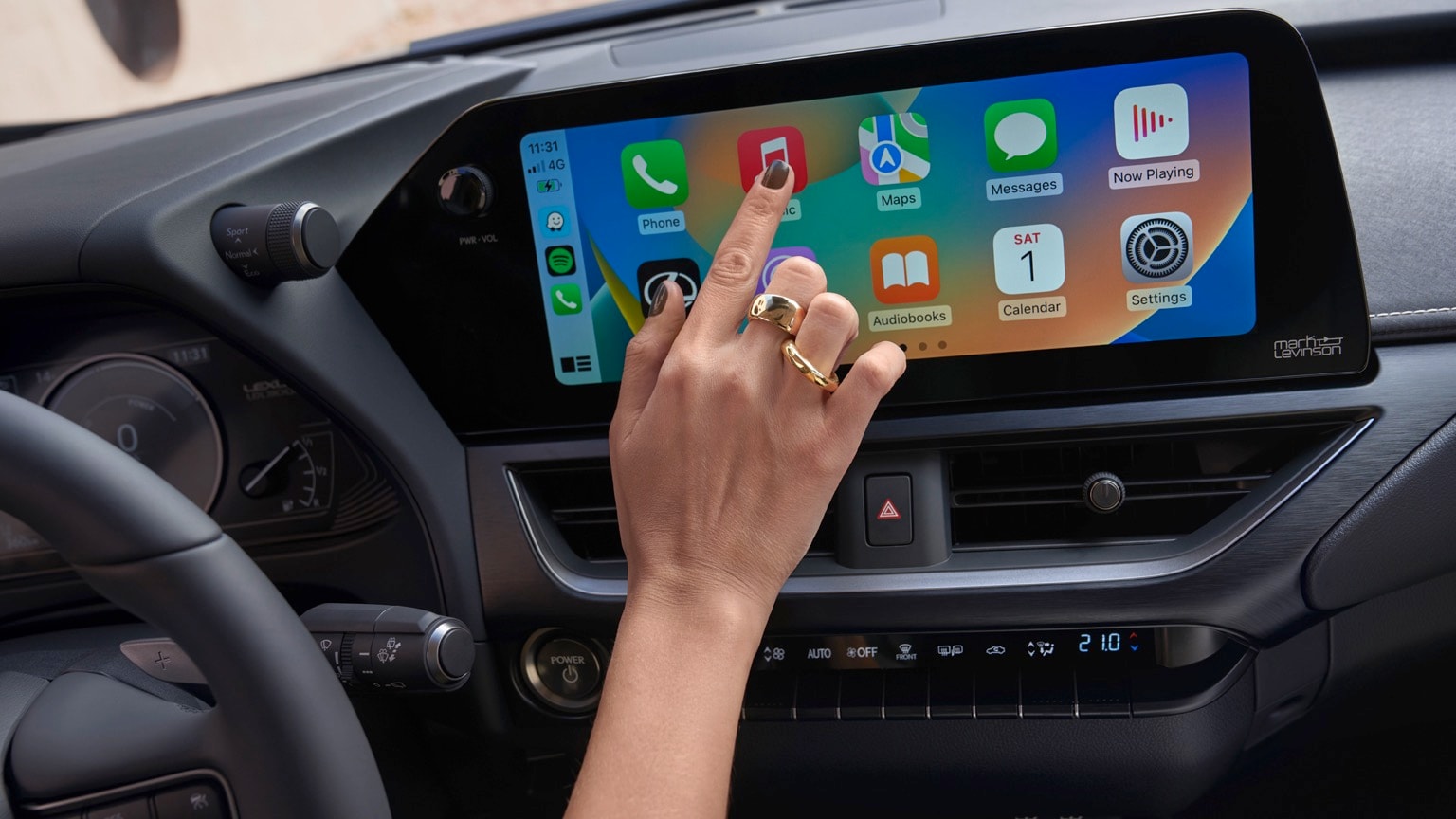 une main touchant un écran tactile dans une voiture