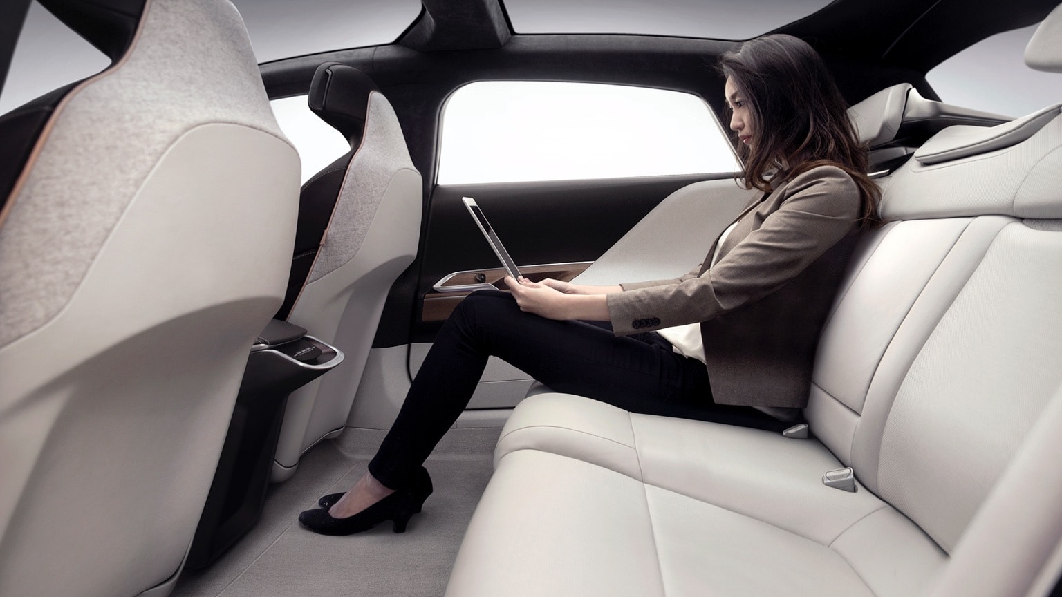 une femme assise dans une voiture avec un ordinateur portable