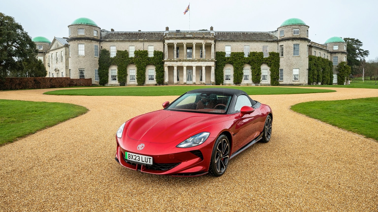 a red sports car parked in front of a large building