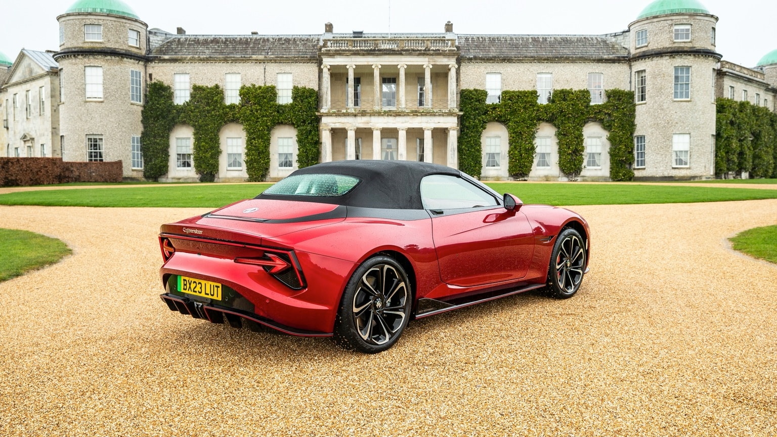 a red sports car parked in front of a large building