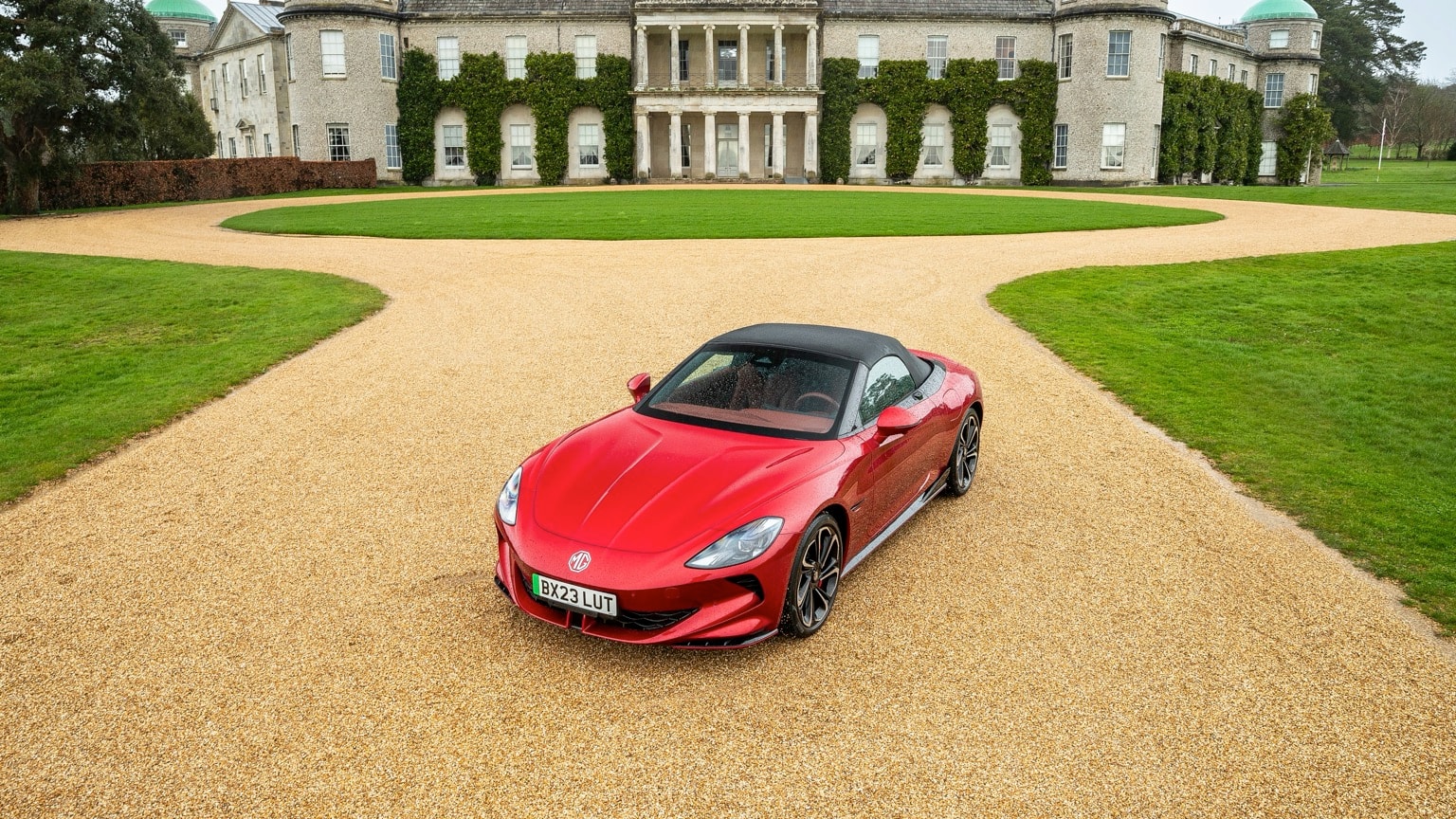 a red sports car parked in front of a large building