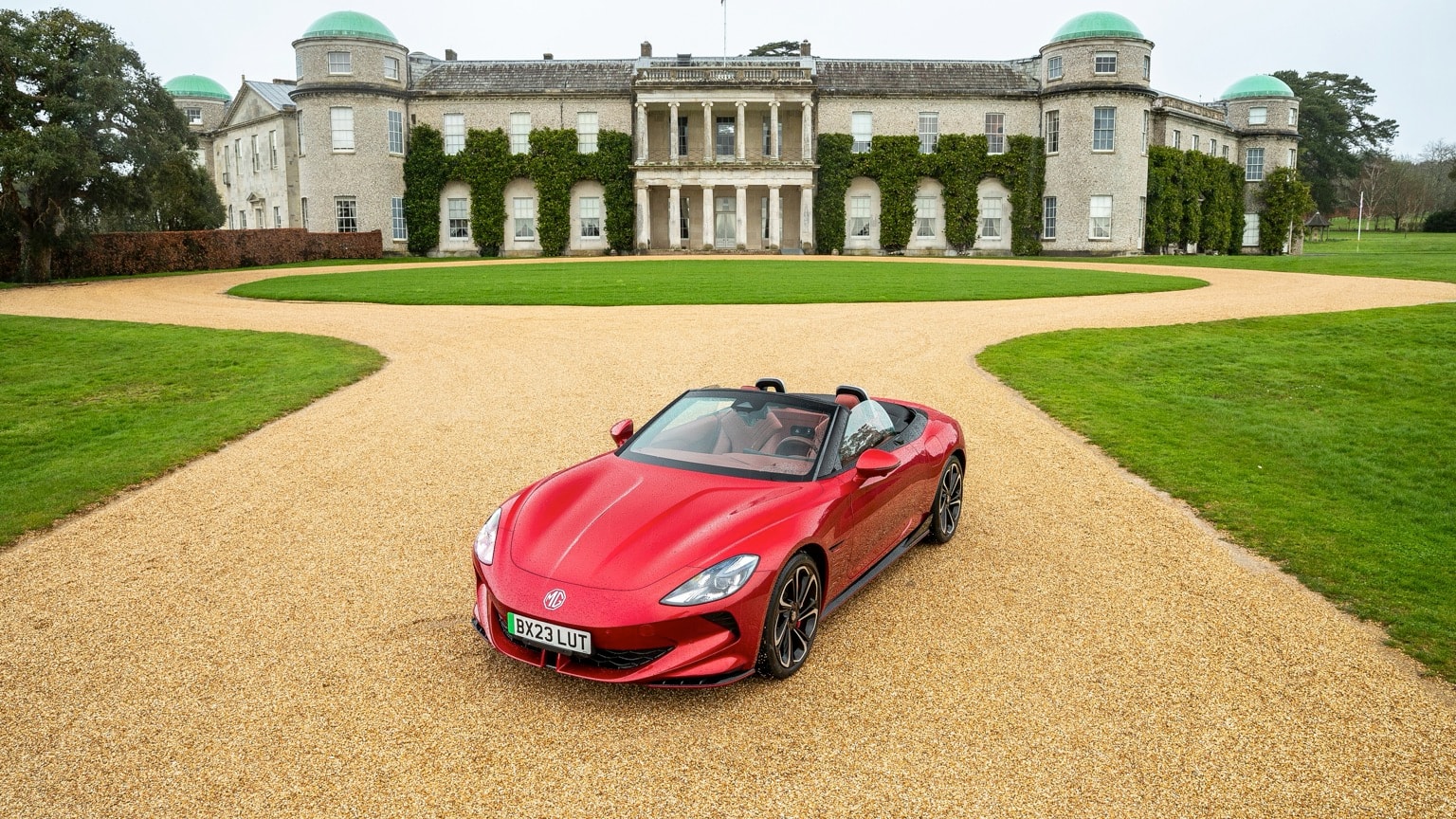 a red sports car parked in front of a large building