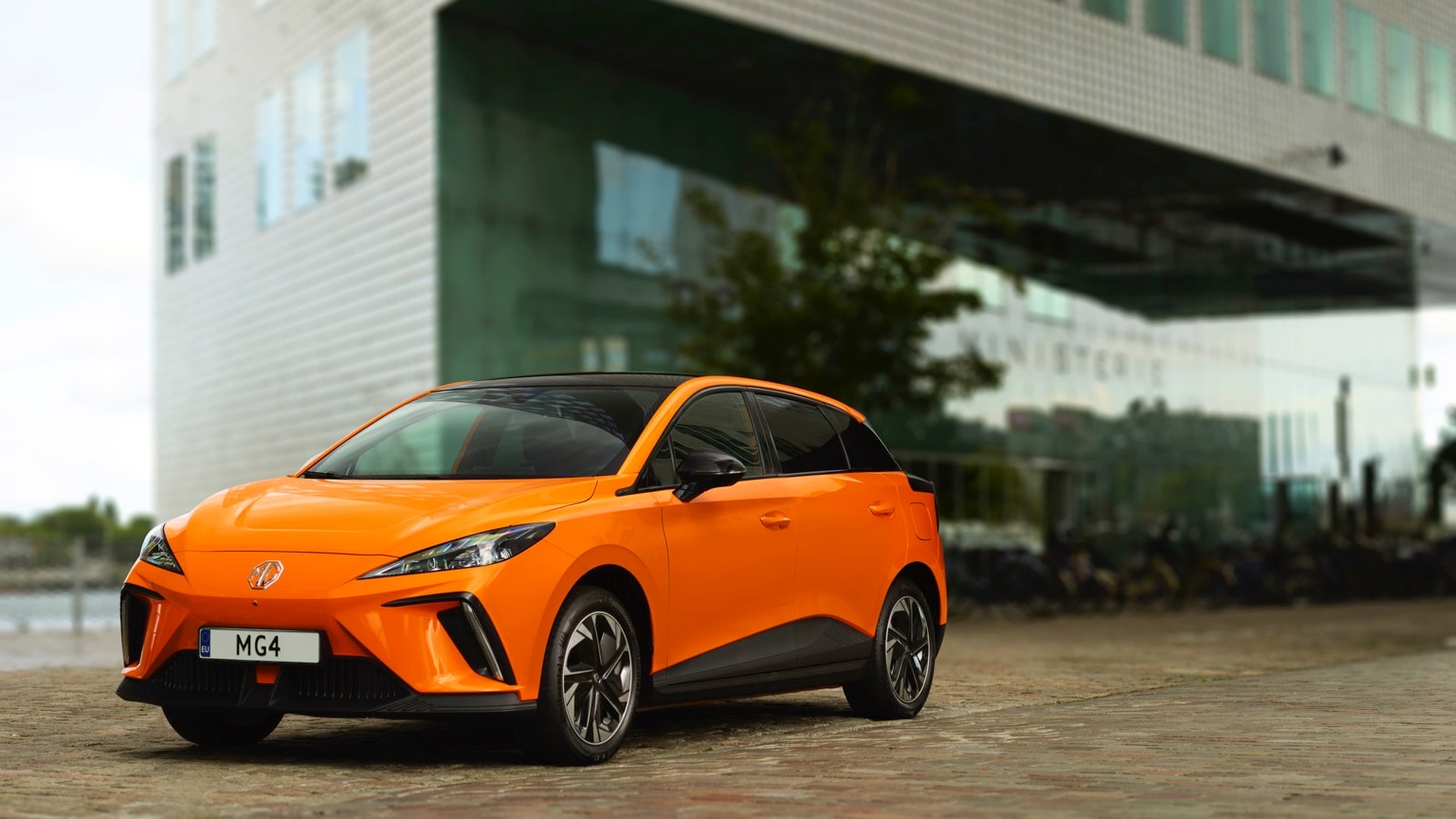 an orange car parked in front of a building