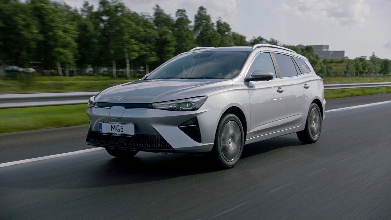 a silver car driving on a road