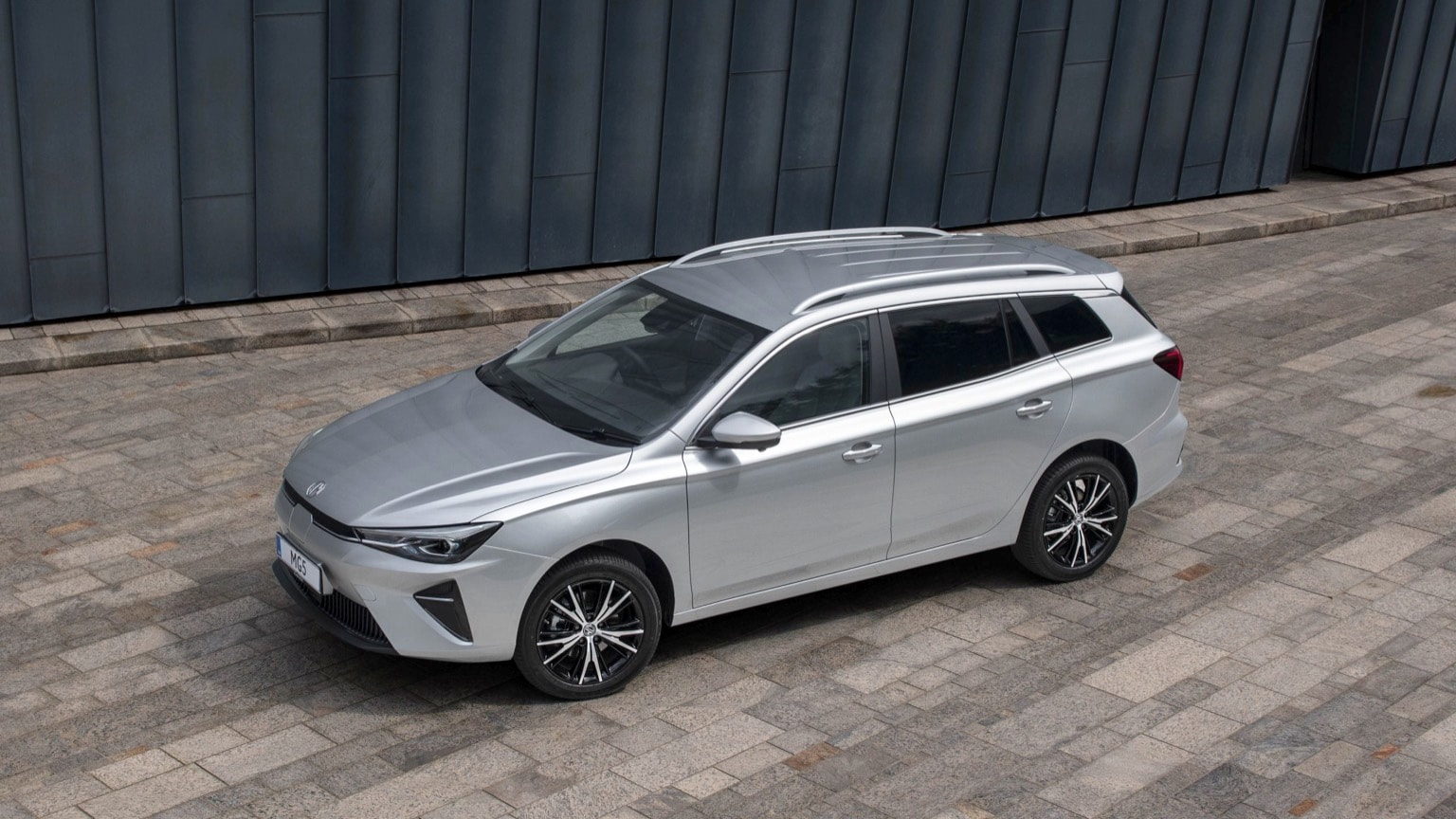 a silver car parked on a brick surface