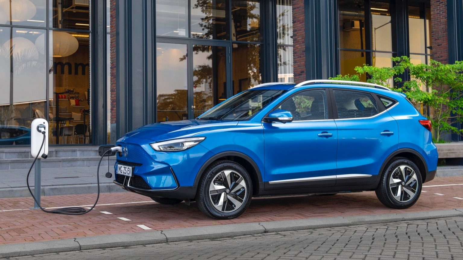 a blue car parked on a brick road