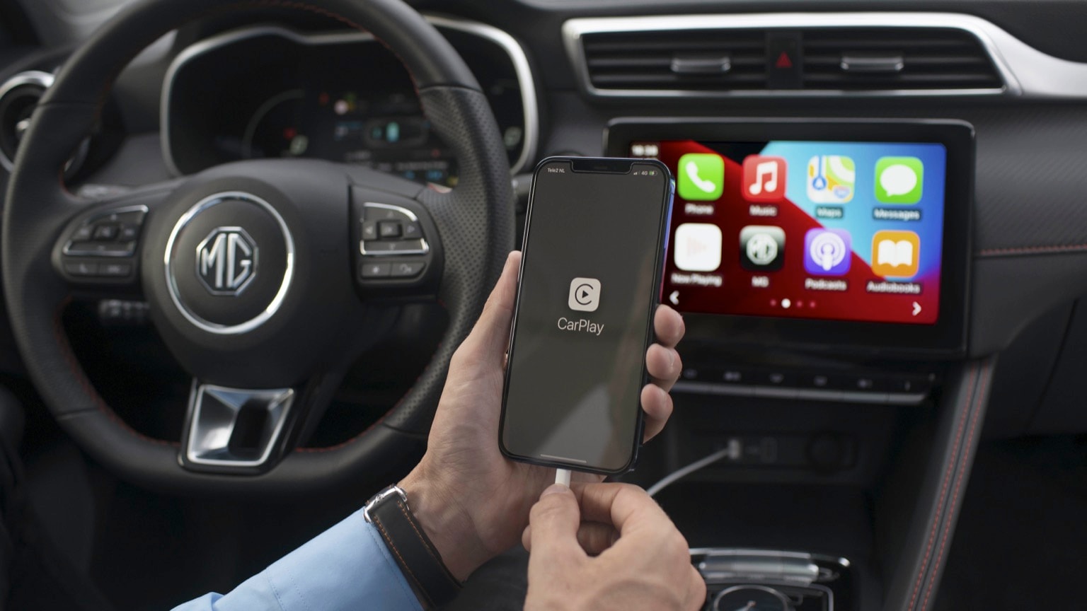a person holding a phone in front of a car