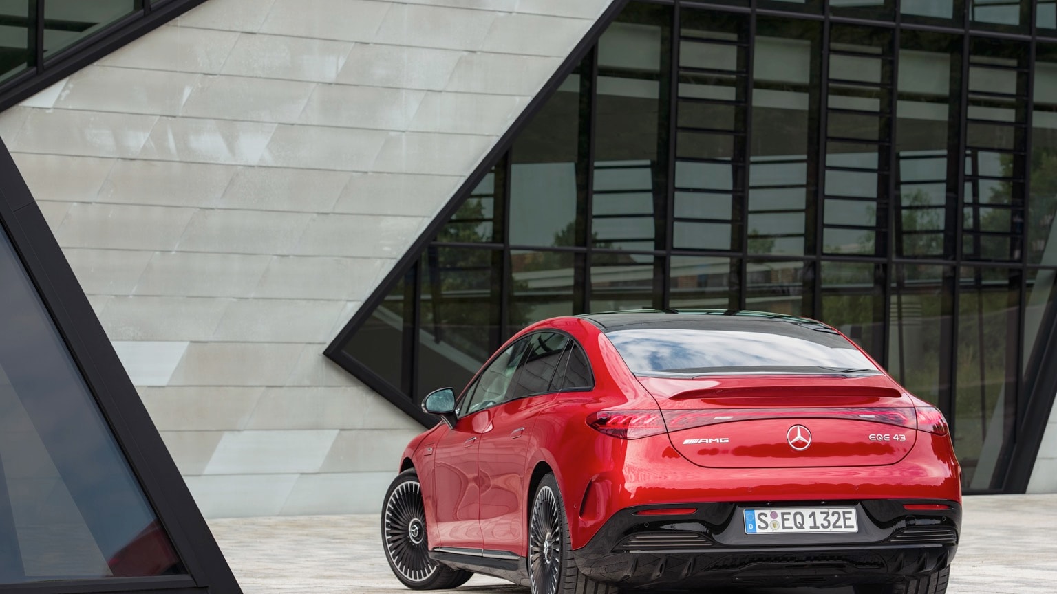 une voiture rouge garée devant un bâtiment