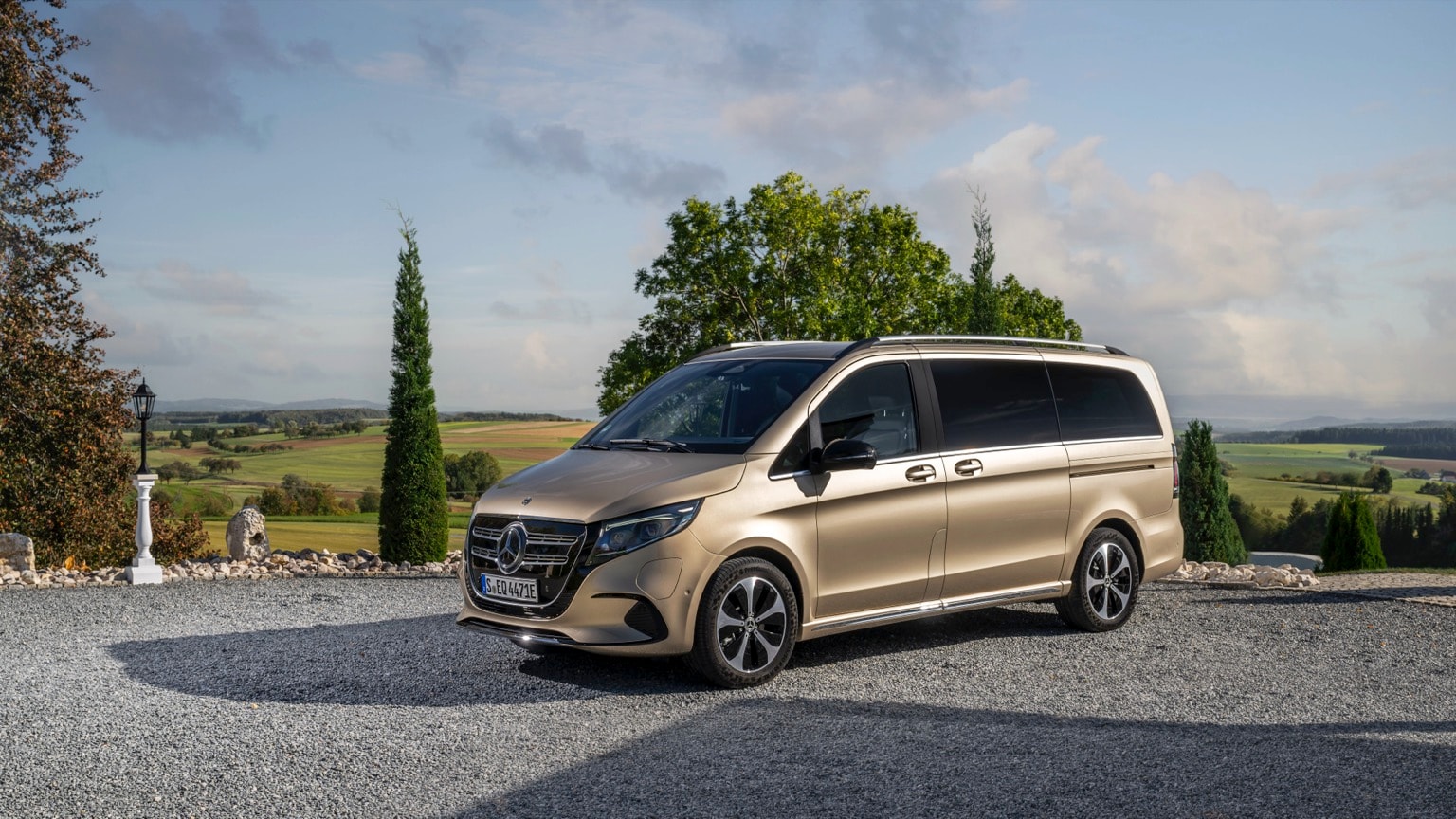 a van parked on gravel near trees