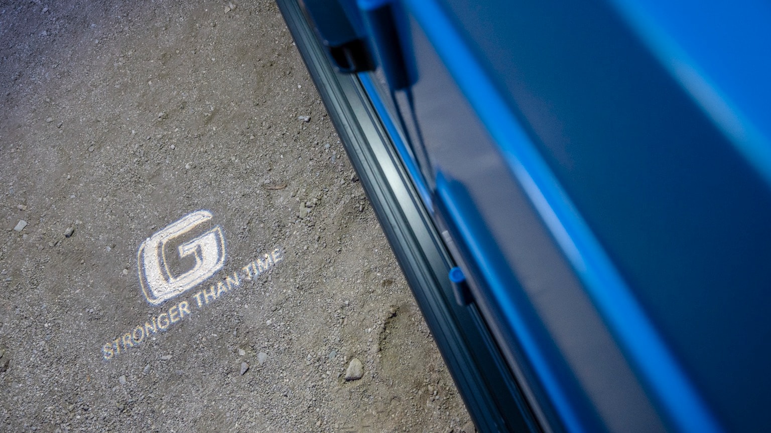 une voiture bleue avec un logo blanc sur le sol