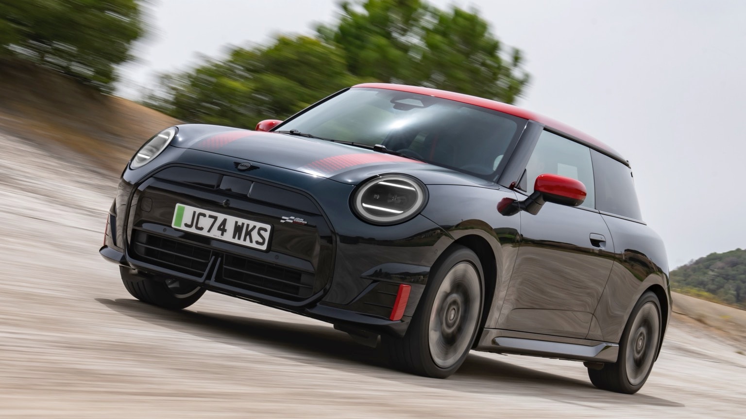 a black and red car driving on a road