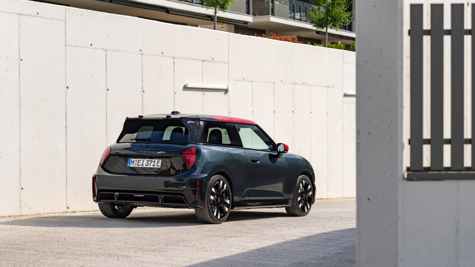 a black car parked in front of a white wall