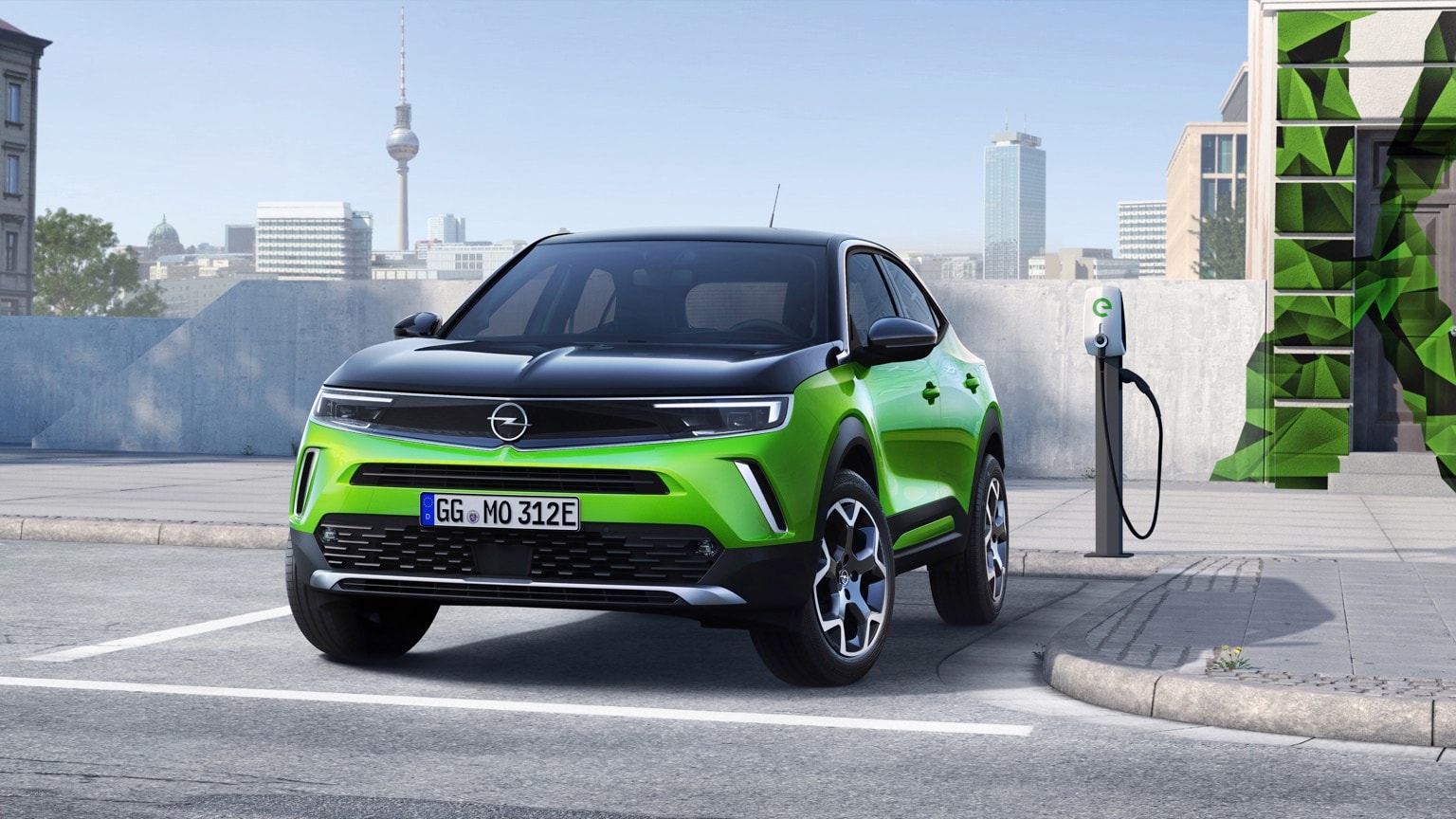 une voiture verte garée à une station de recharge