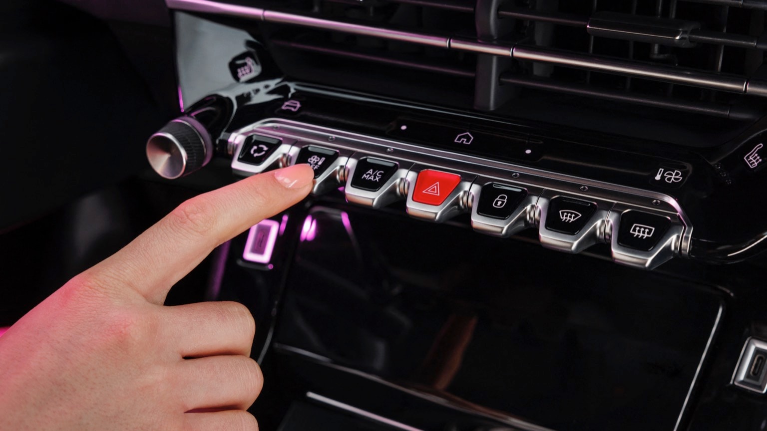a finger pressing a button on a car dashboard