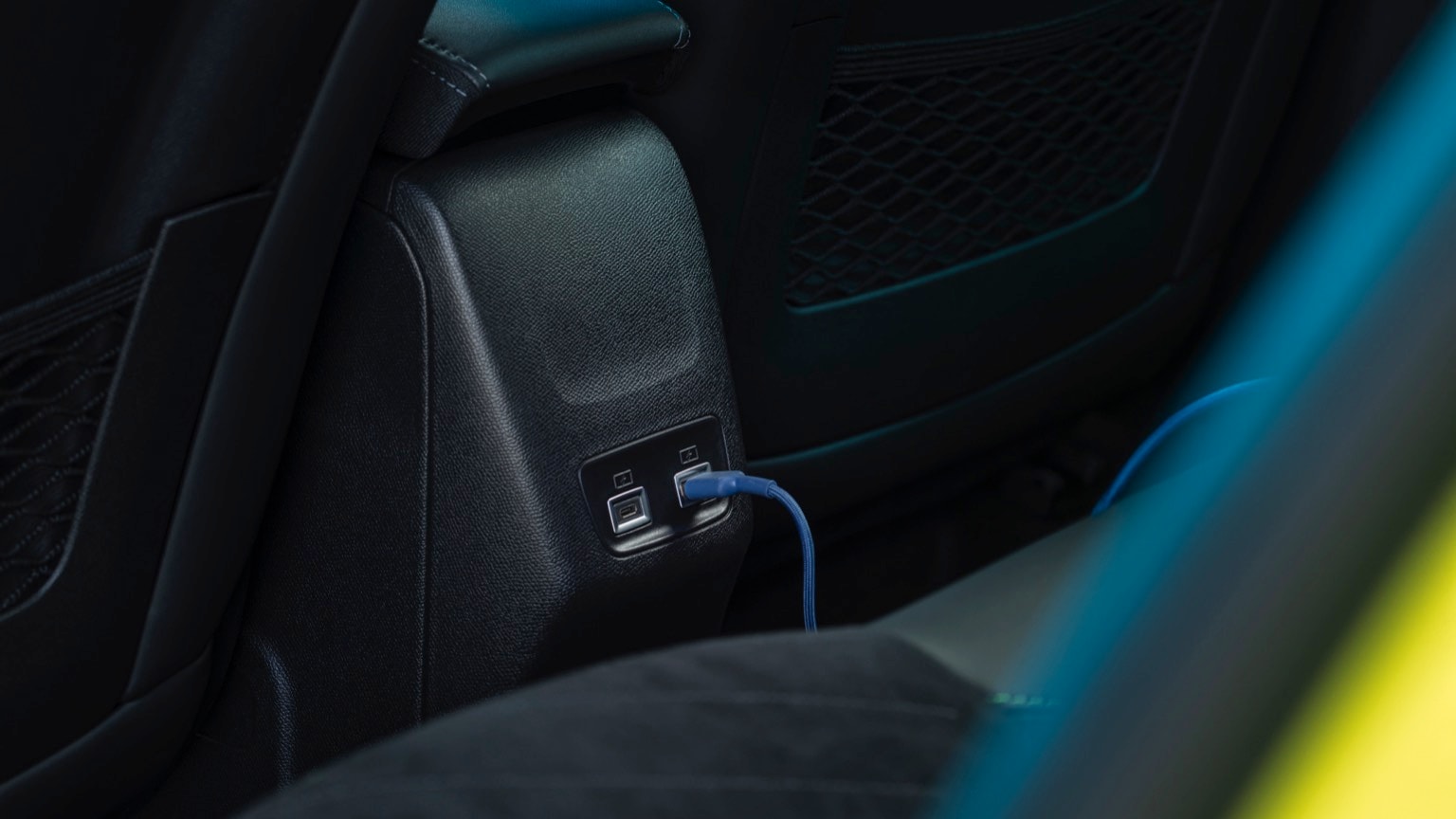 un câble bleu branché sur le panneau noir d'une voiture