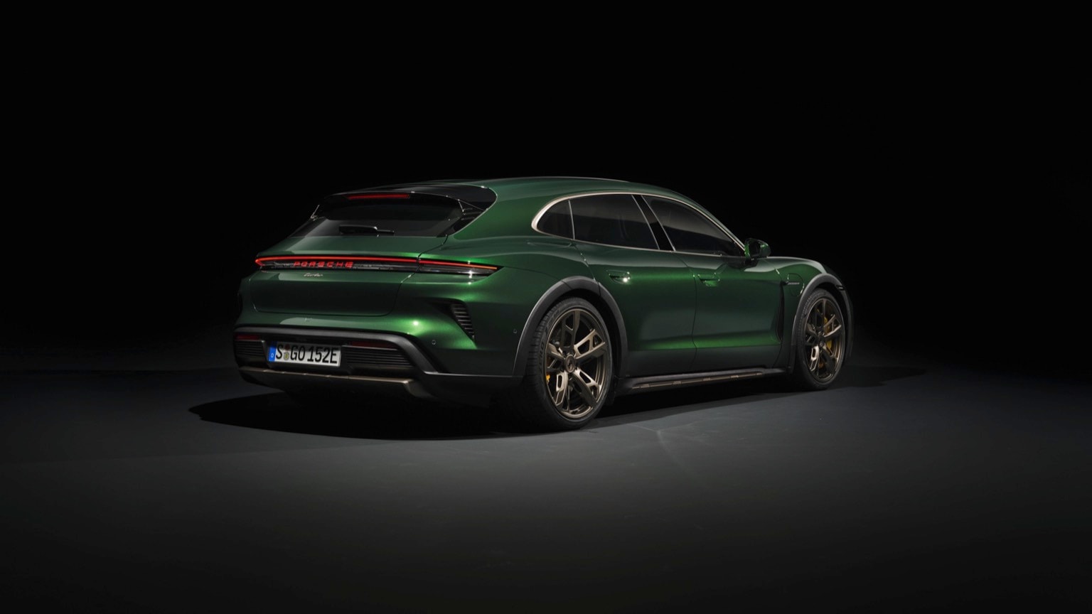 a green sports car in a dark room