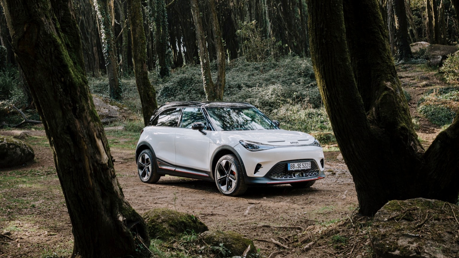a white car parked on a dirt road in the woods