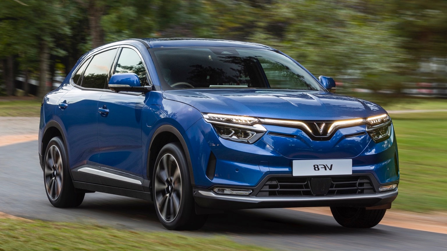 une voiture bleue roulant sur une route