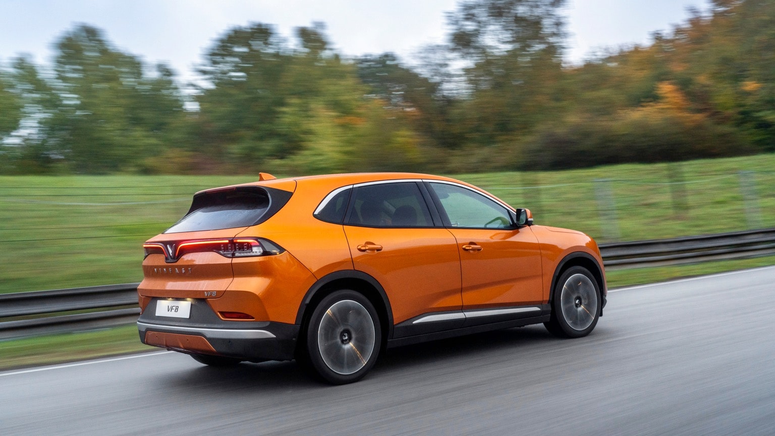 une voiture orange roulant sur une route