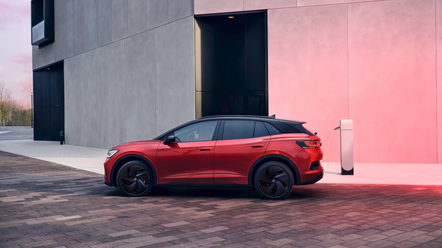 une voiture rouge garée à côté d'un bâtiment