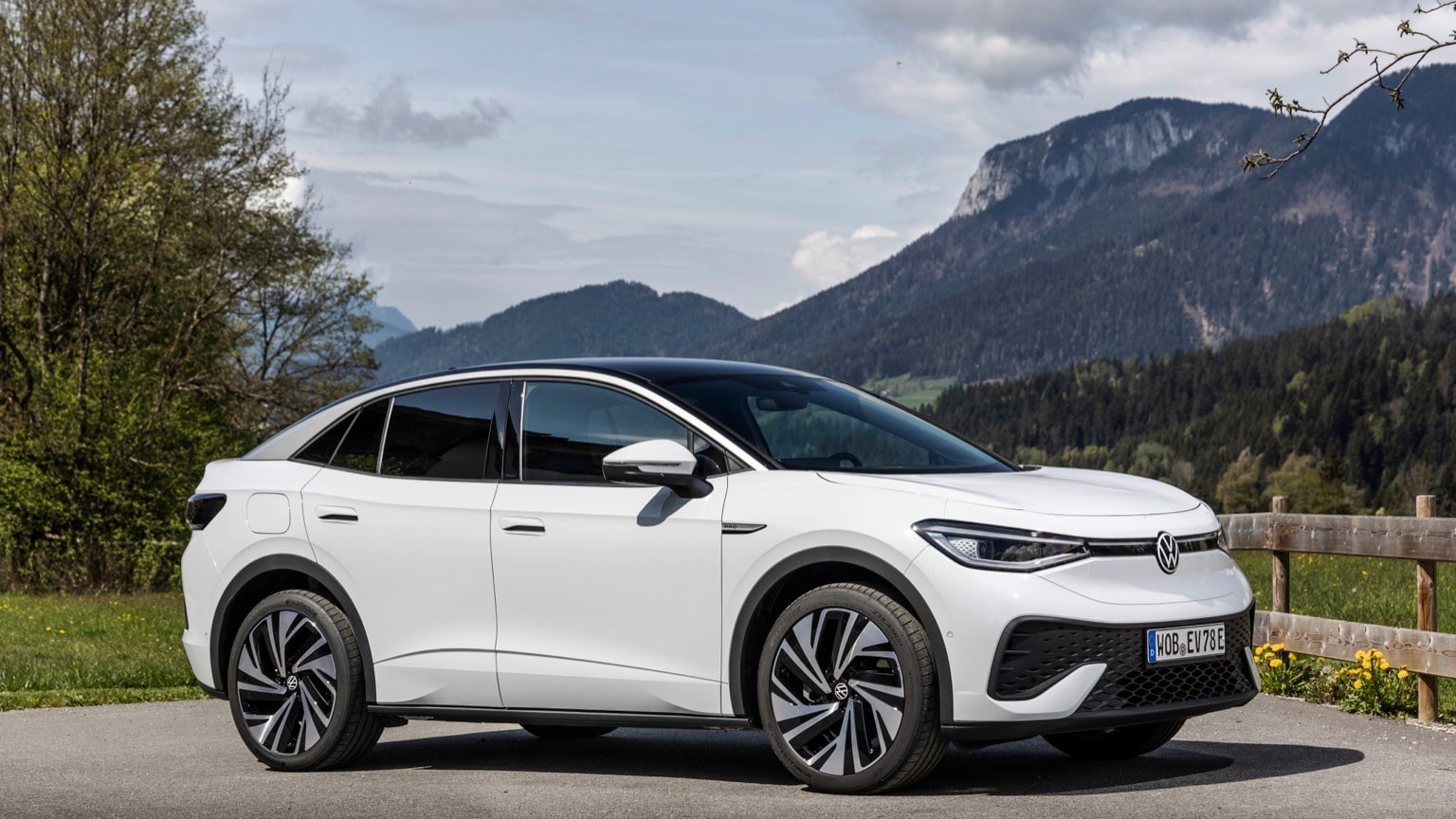 a white car parked on a road with mountains in the background