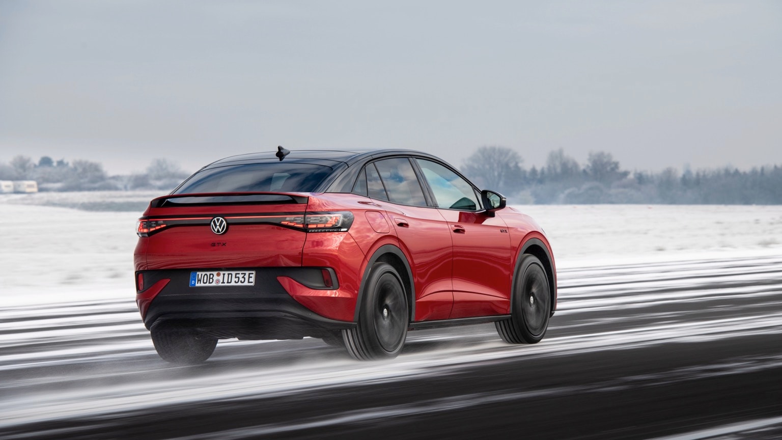 a red car driving on a snowy road