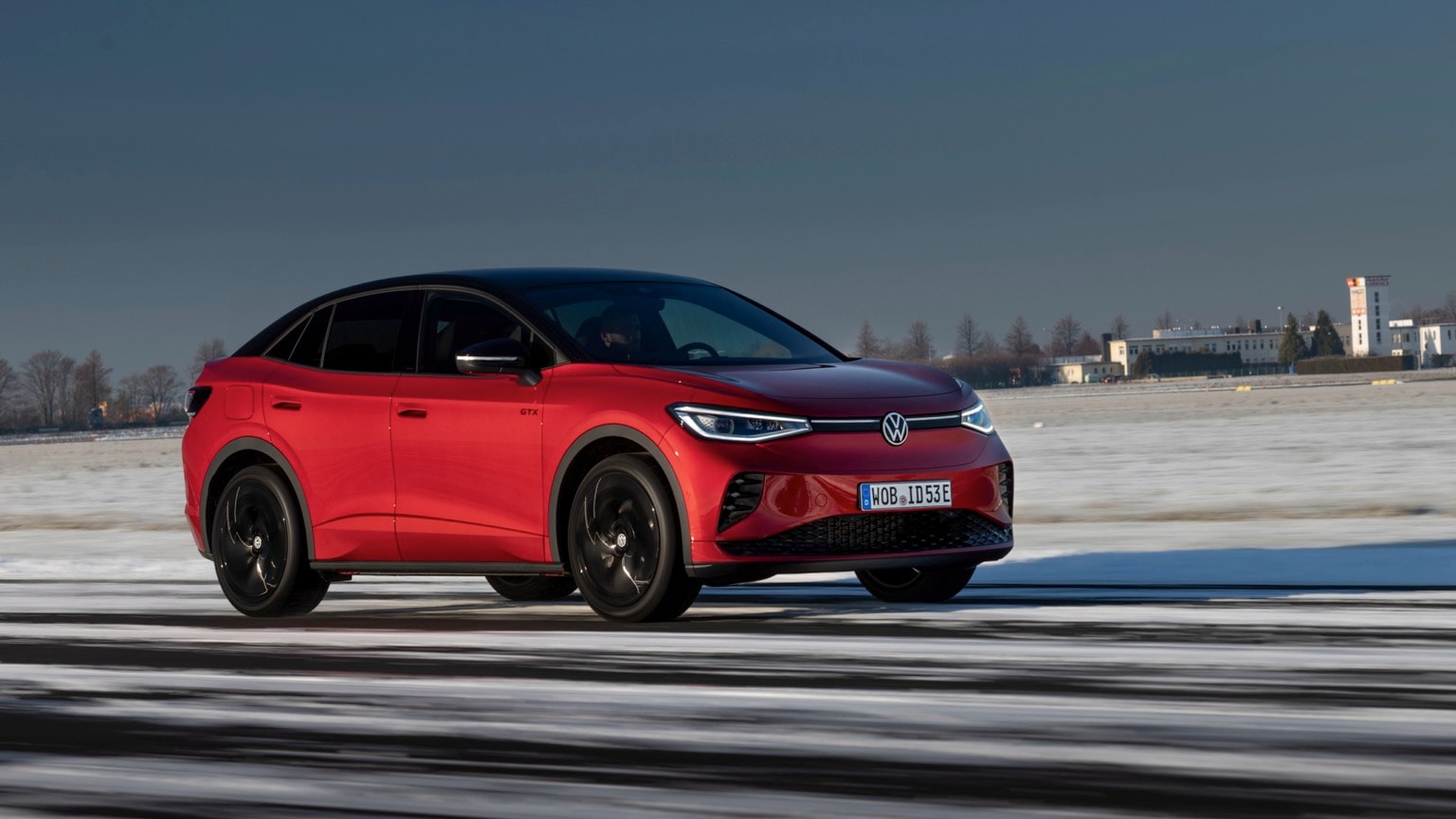 a red car driving on a snowy road