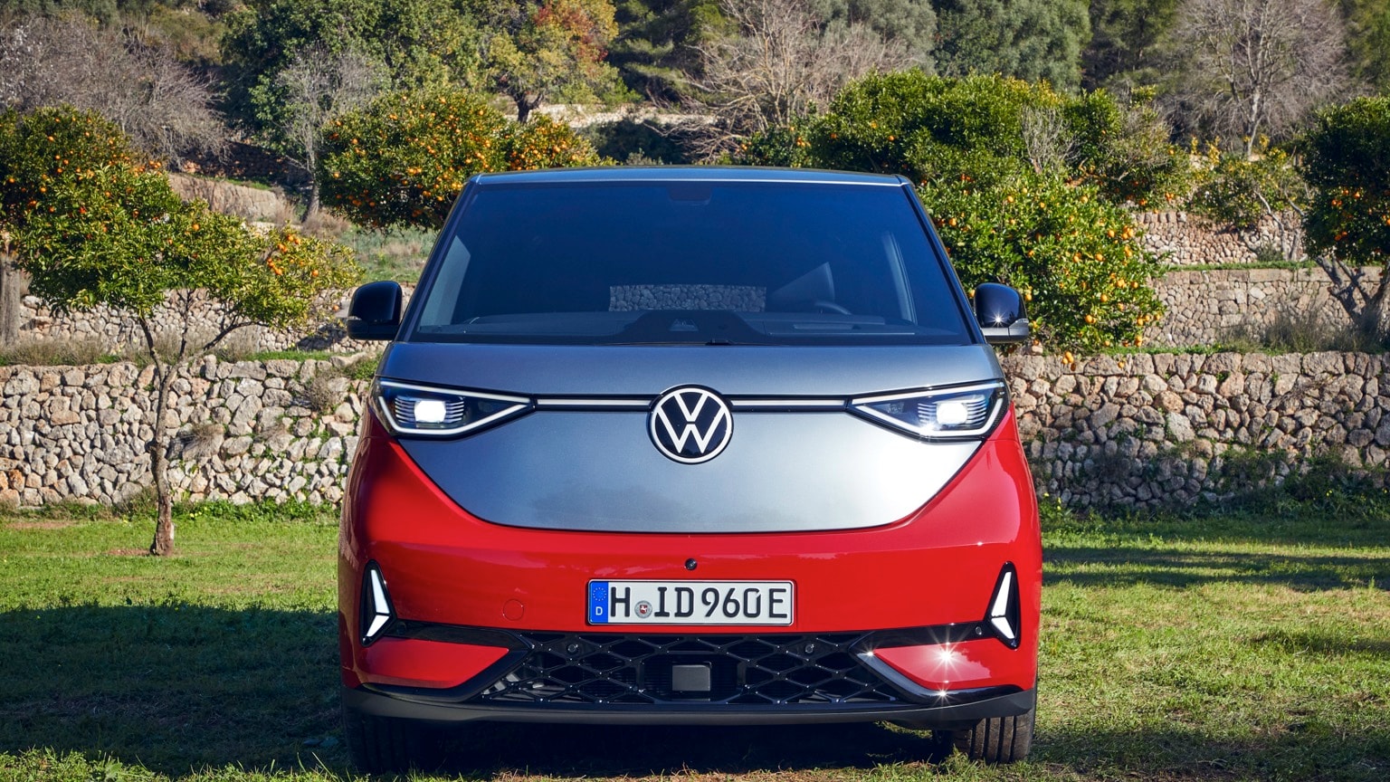 une voiture rouge et argentée garée sur l'herbe
