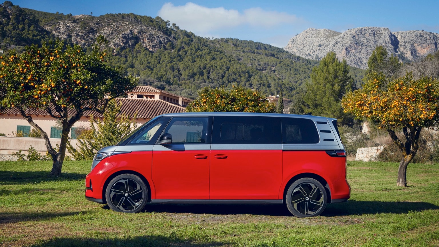 une camionnette rouge garée sur l'herbe près d'une maison